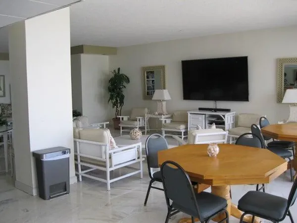 a living room with furniture a flat screen tv and kitchen view