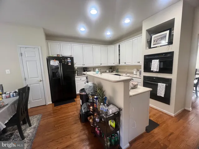 a open kitchen with refrigerator stove dining table and chairs