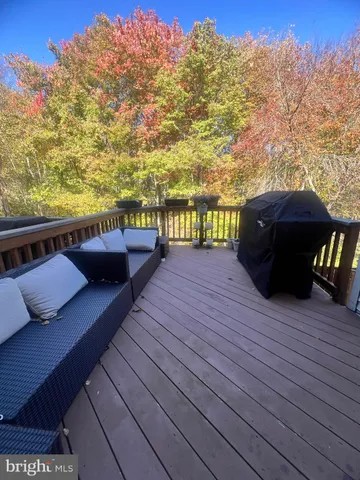 a view of a roof deck with couches and wooden fence