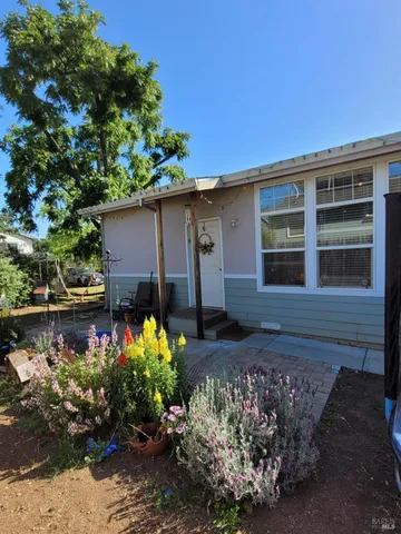 a view of a house with backyard and sitting area