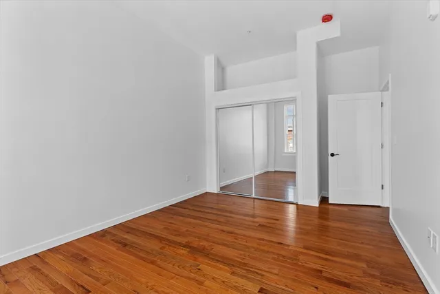 a view of room with wooden floor and white walls