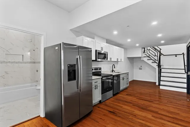 a kitchen with stainless steel appliances granite countertop a refrigerator and a sink