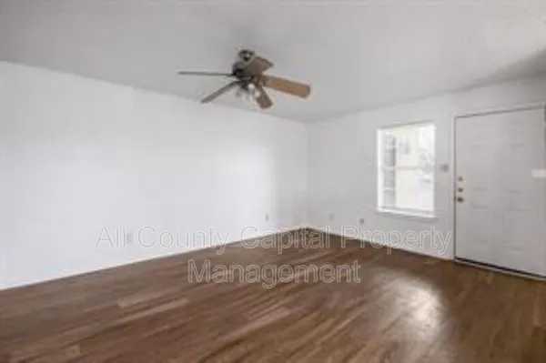 a view of a room with wooden floor and fan