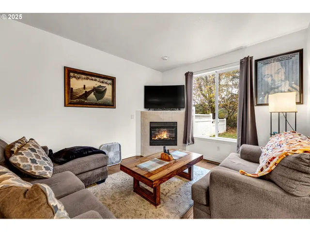 a living room with furniture a flat screen tv and a fireplace