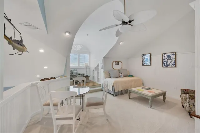 a view of a dining room and livingroom with furniture a rug a fireplace and a chandelier