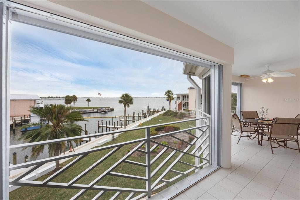11000 Placida Road, Unit 2103 Placida, FL 33946 - Photo 9 of 63 a view of a balcony with dining table and chairs with wooden floor