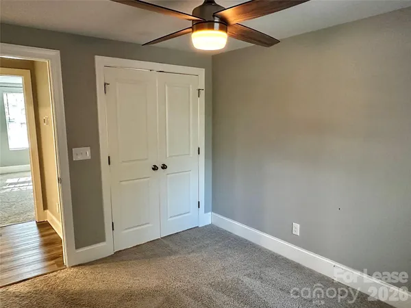 an empty room with a ceiling fan and a window