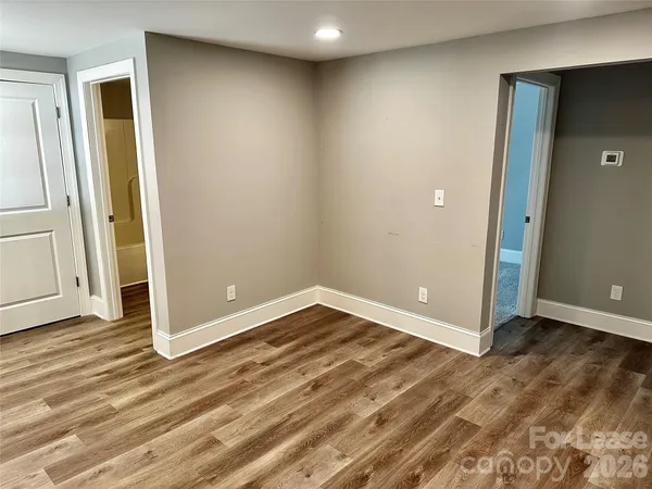 an empty room with wooden floor and entrance