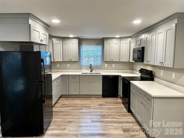a kitchen with a sink refrigerator and cabinets