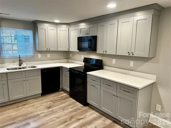 a kitchen with a sink dishwasher a stove and a microwave oven