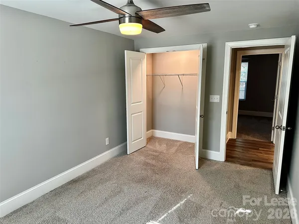 an empty room with closet and windows