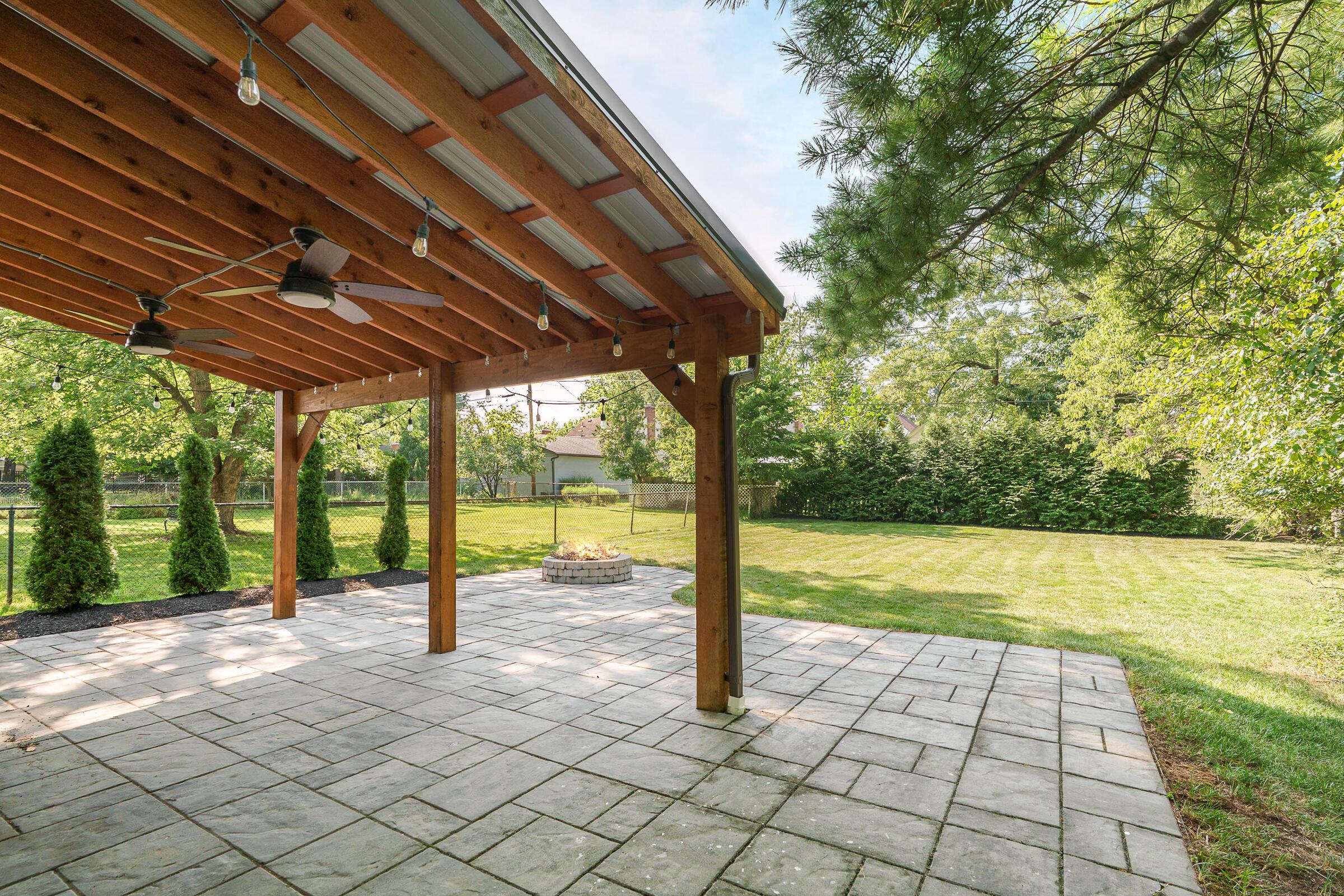 163 Garden Road Columbus, OH 43214 - Photo 4 of 46 The 2nd patio features a covered paver patio with ceiling fan and built-in firepit, open to the expansive yard in a private setting.