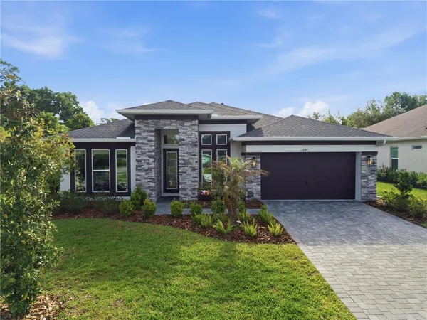a front view of a house with a garden and yard