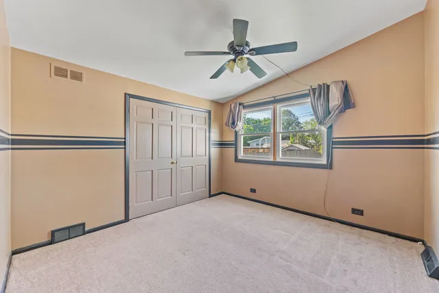 a view of a room with a ceiling fan and wooden floor