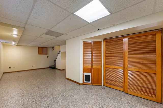 a view of a chair and table in the back yard of the house