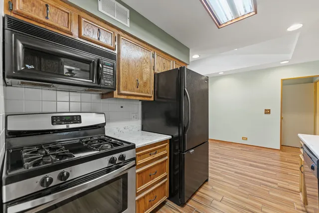 a kitchen with stainless steel appliances granite countertop a stove and a refrigerator