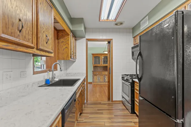 a kitchen with stainless steel appliances granite countertop a sink stove and refrigerator