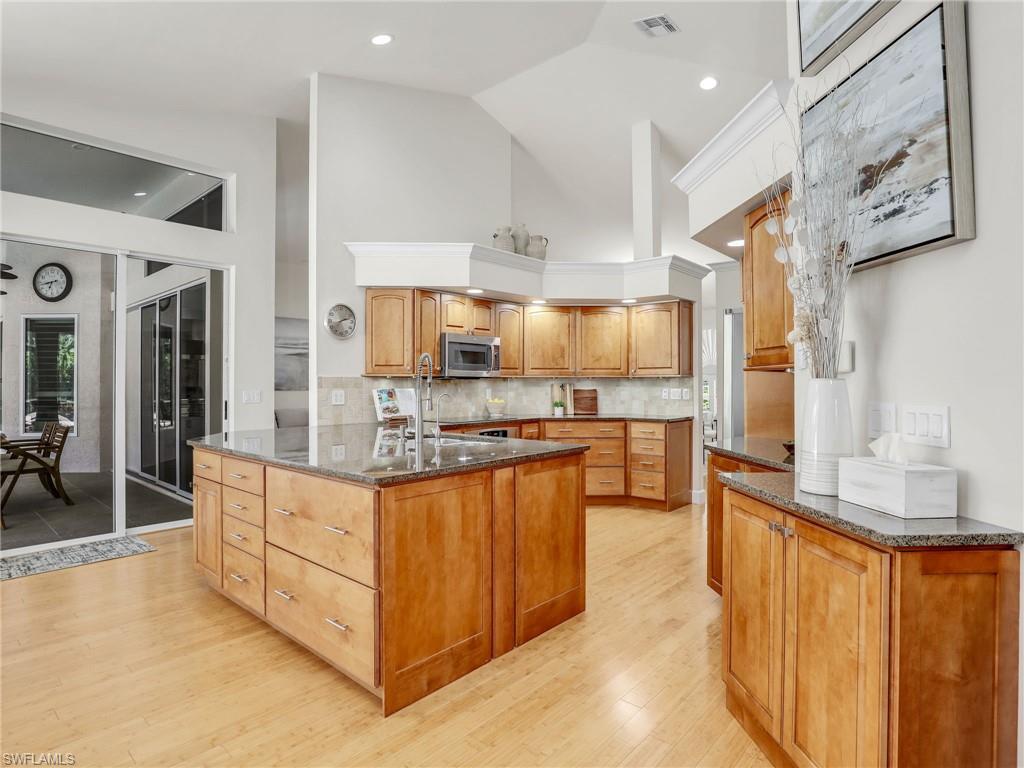 6862 Mill Run Road Naples, FL 34109 - Photo 11 of 50 Kitchen with decorative backsplash, light wood-type flooring, stainless steel appliances, and sink