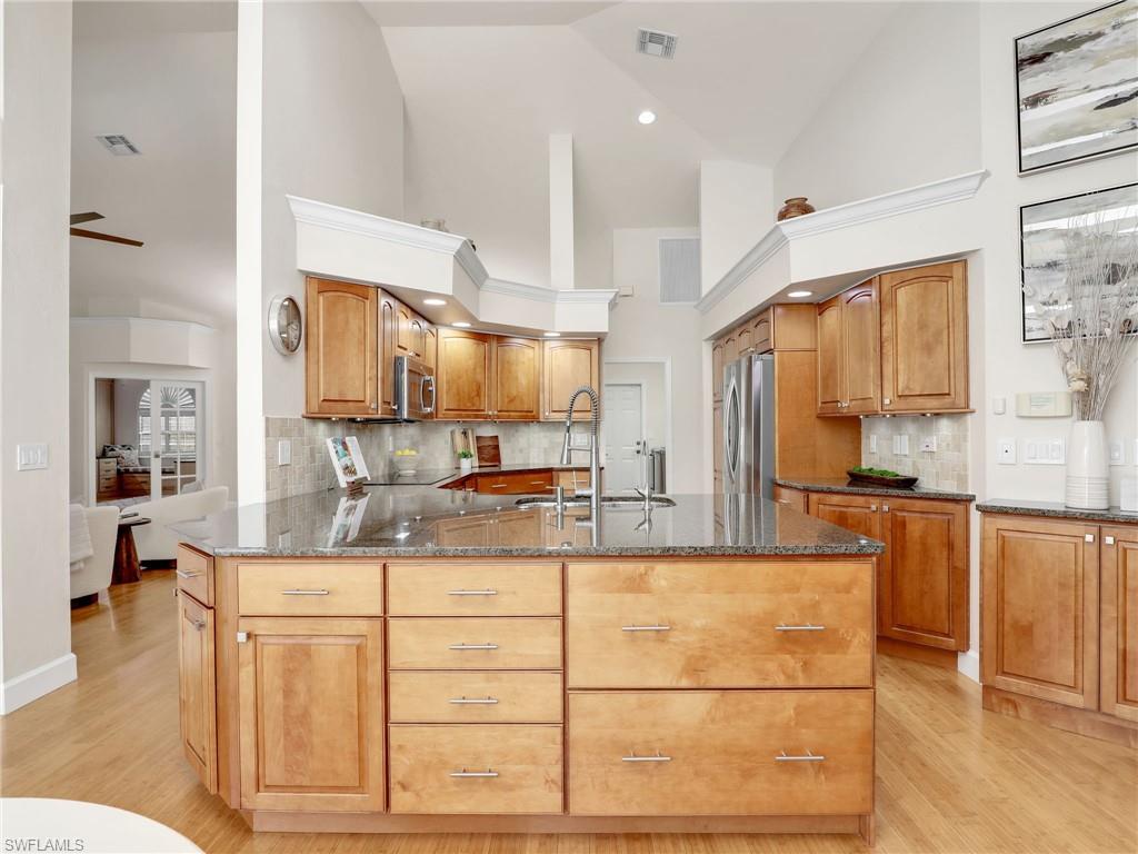 6862 Mill Run Road Naples, FL 34109 - Photo 16 of 50 Dining space featuring wine cooler, ceiling fan with notable chandelier, and light hardwood / wood-style floors