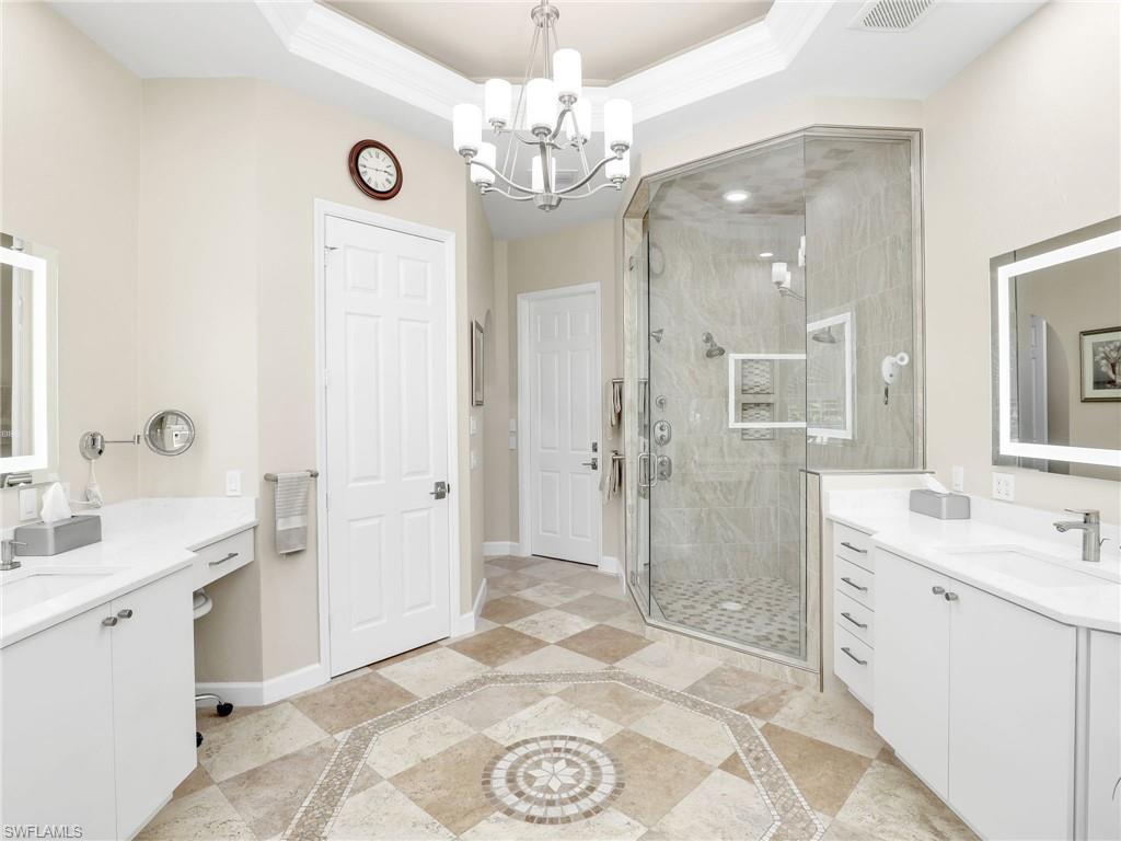 6862 Mill Run Road Naples, FL 34109 - Photo 26 of 50 Bathroom with a notable chandelier, vanity, a shower with door, and tile patterned flooring