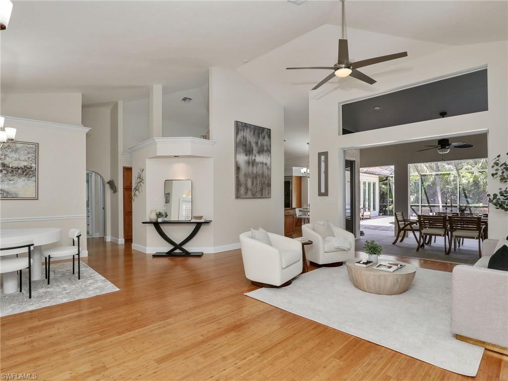 6862 Mill Run Road Naples, FL 34109 - Photo 7 of 50 Living room featuring lofted ceiling, light hardwood / wood-style flooring, and ceiling fan with notable chandelier
