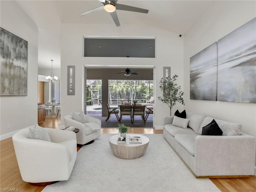 6862 Mill Run Road Naples, FL 34109 - Photo 8 of 50 Living room featuring light wood-type flooring, french doors, ceiling fan with notable chandelier, and vaulted ceiling