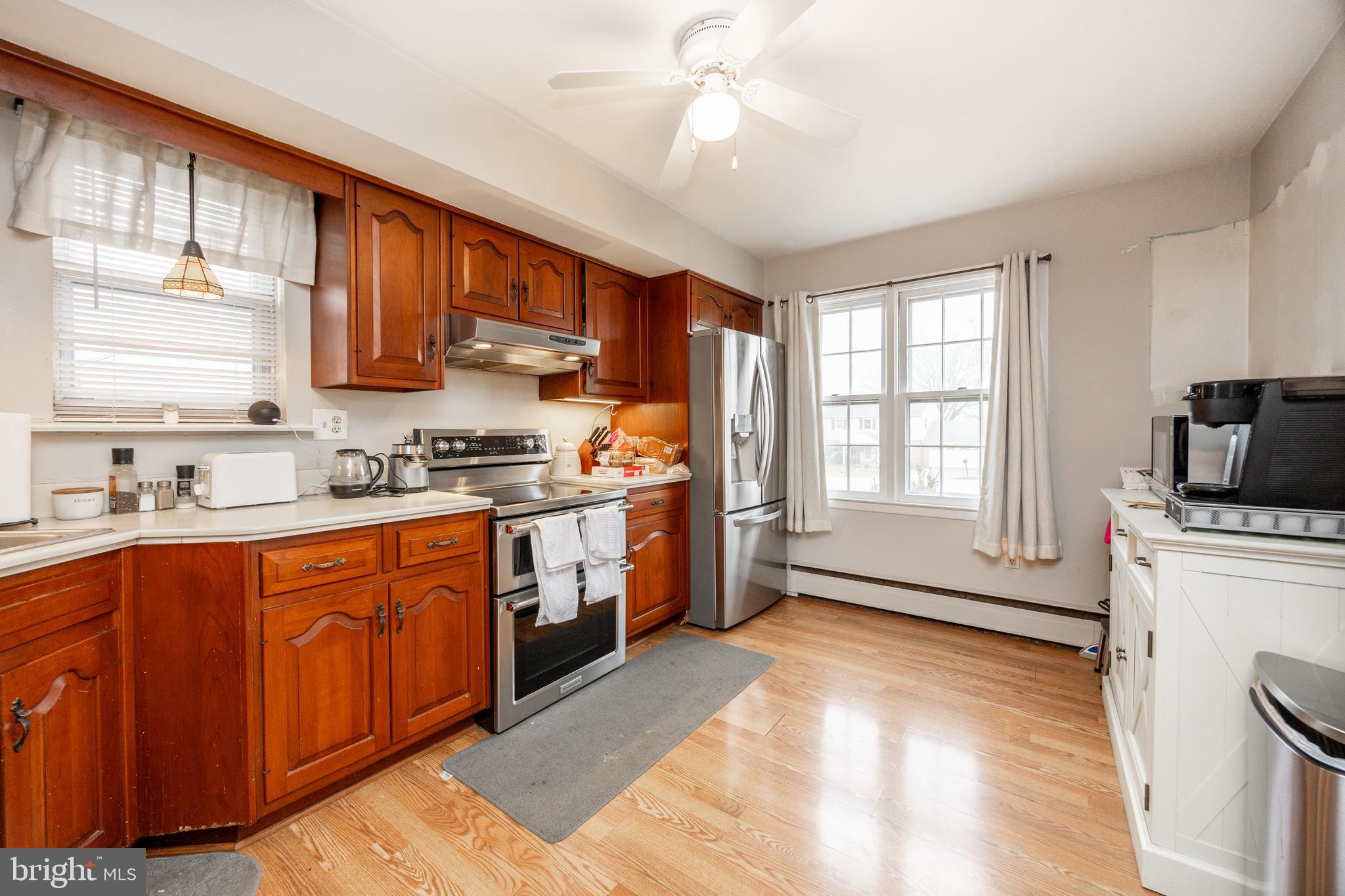 149 Conestoga Road Malvern, PA 19355 - Photo 7 of 43 a kitchen with stainless steel appliances granite countertop a stove a sink dishwasher and a refrigerator with wooden floor
