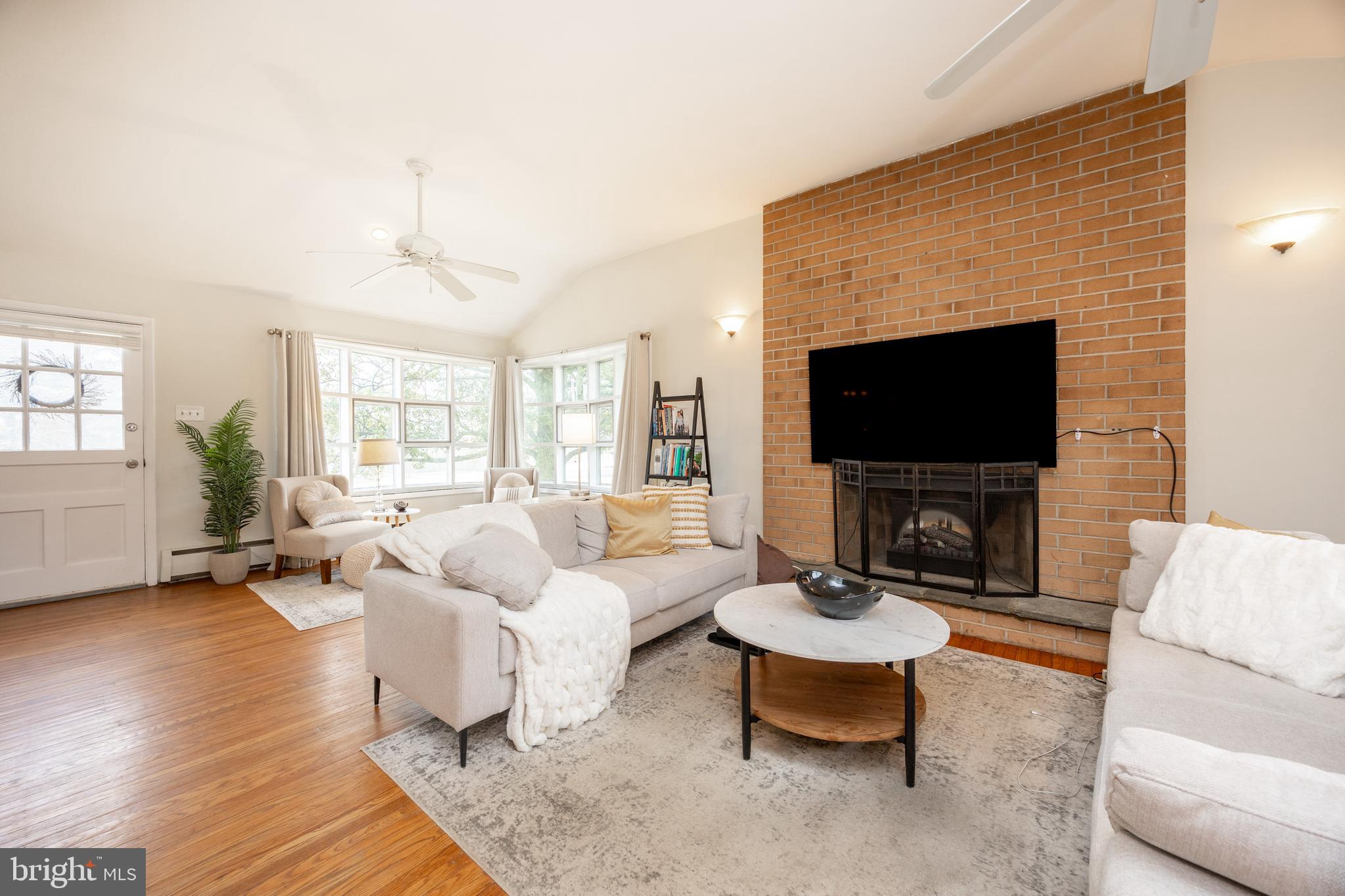 149 Conestoga Road Malvern, PA 19355 - Photo 10 of 43 a living room with furniture a fireplace and a flat screen tv