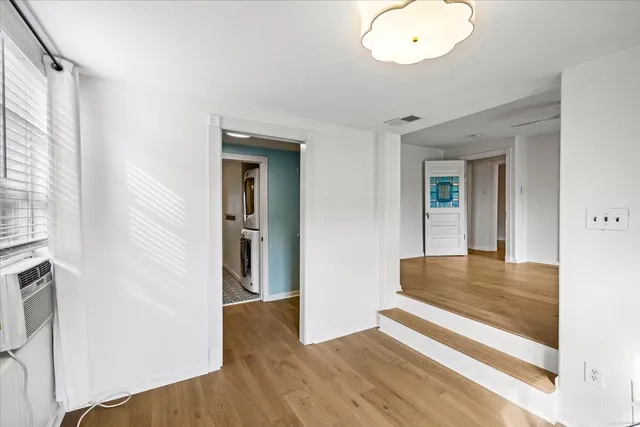 a view of a hallway with wooden floor and cabinet