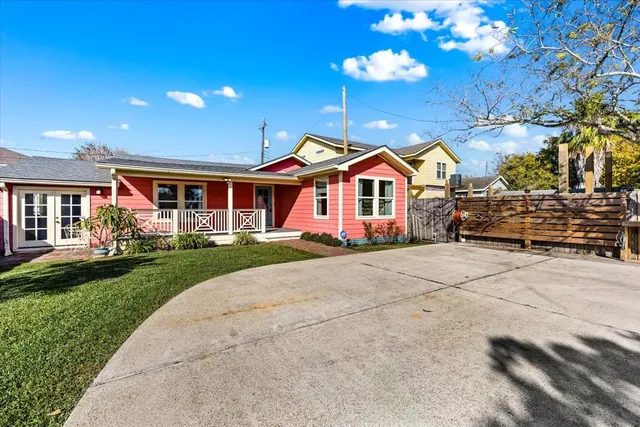 a front view of a house with a garden and trees
