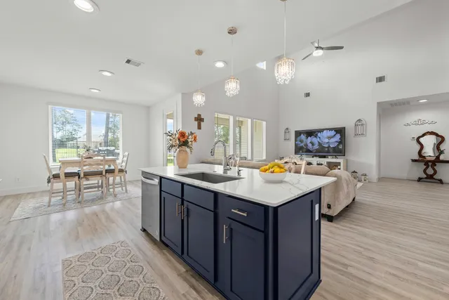 a kitchen with kitchen island wooden floors and living room