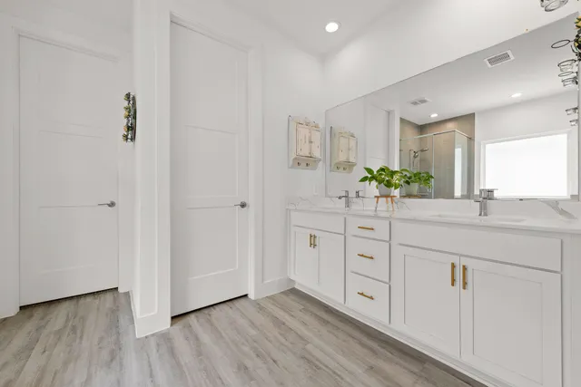 a spacious bathroom with a double vanity sink and a mirror