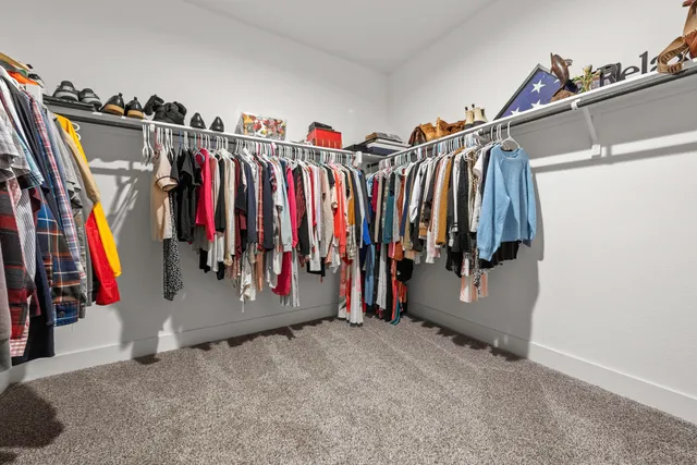 a view of walk in closet with clothes