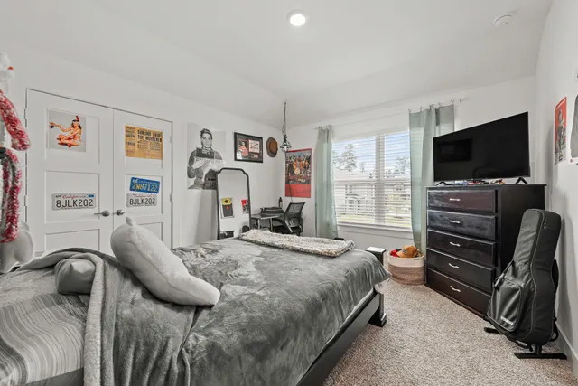 a bedroom with a bed and a flat screen tv