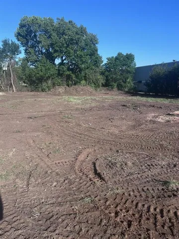 a view of a field with trees in the background