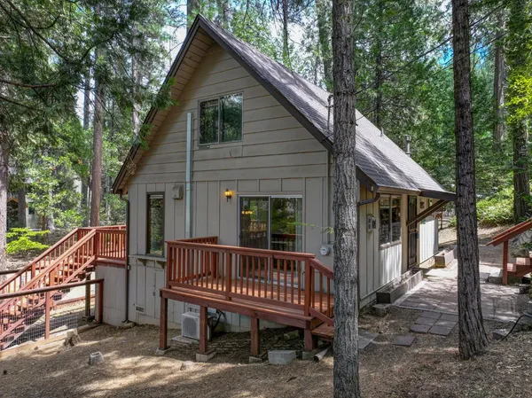 a view of a house with a wooden deck and backyard