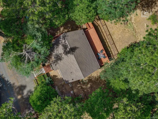 an aerial view of a house with table and chairs and potted plants