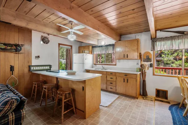 a kitchen with stainless steel appliances granite countertop a stove a sink a dining table and chairs with wooden floor