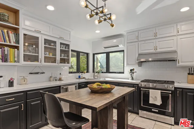 a kitchen with stainless steel appliances granite countertop a sink a stove and a refrigerator