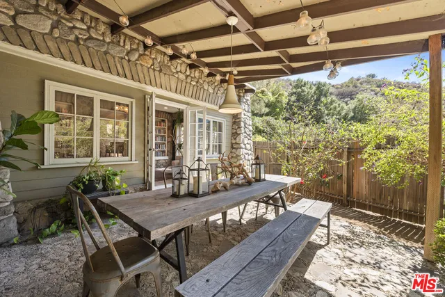 a view of a patio with table and chairs with wooden floor and fence