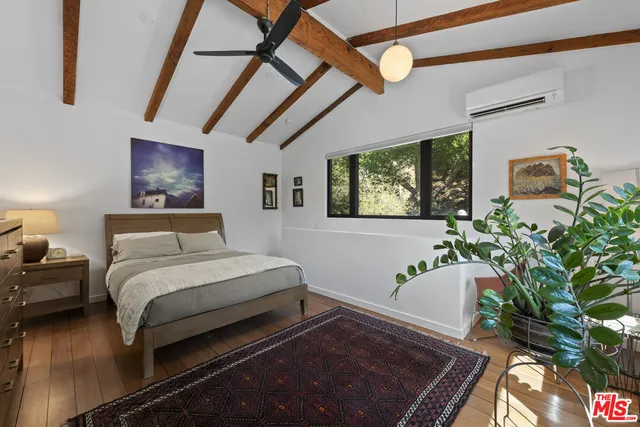 a bedroom with a bed and a potted plant