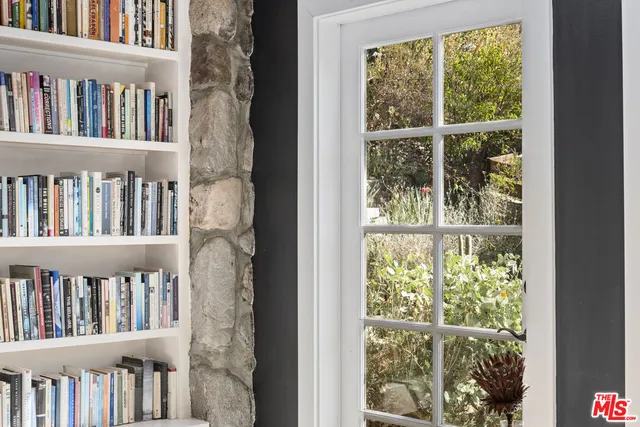a shelf of books and window in a room