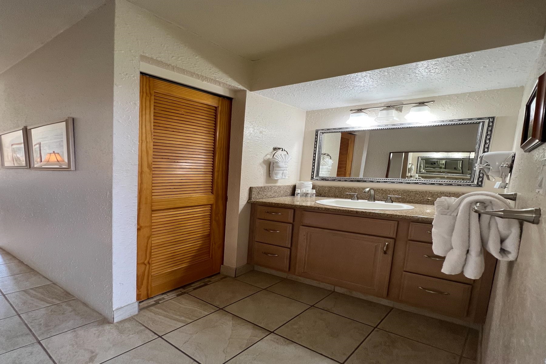 3601 Lower Honoapiilani Road, Unit 414 Lahaina, HI 96761 - Photo 17 of 28 a spacious bathroom with a sink and a mirror