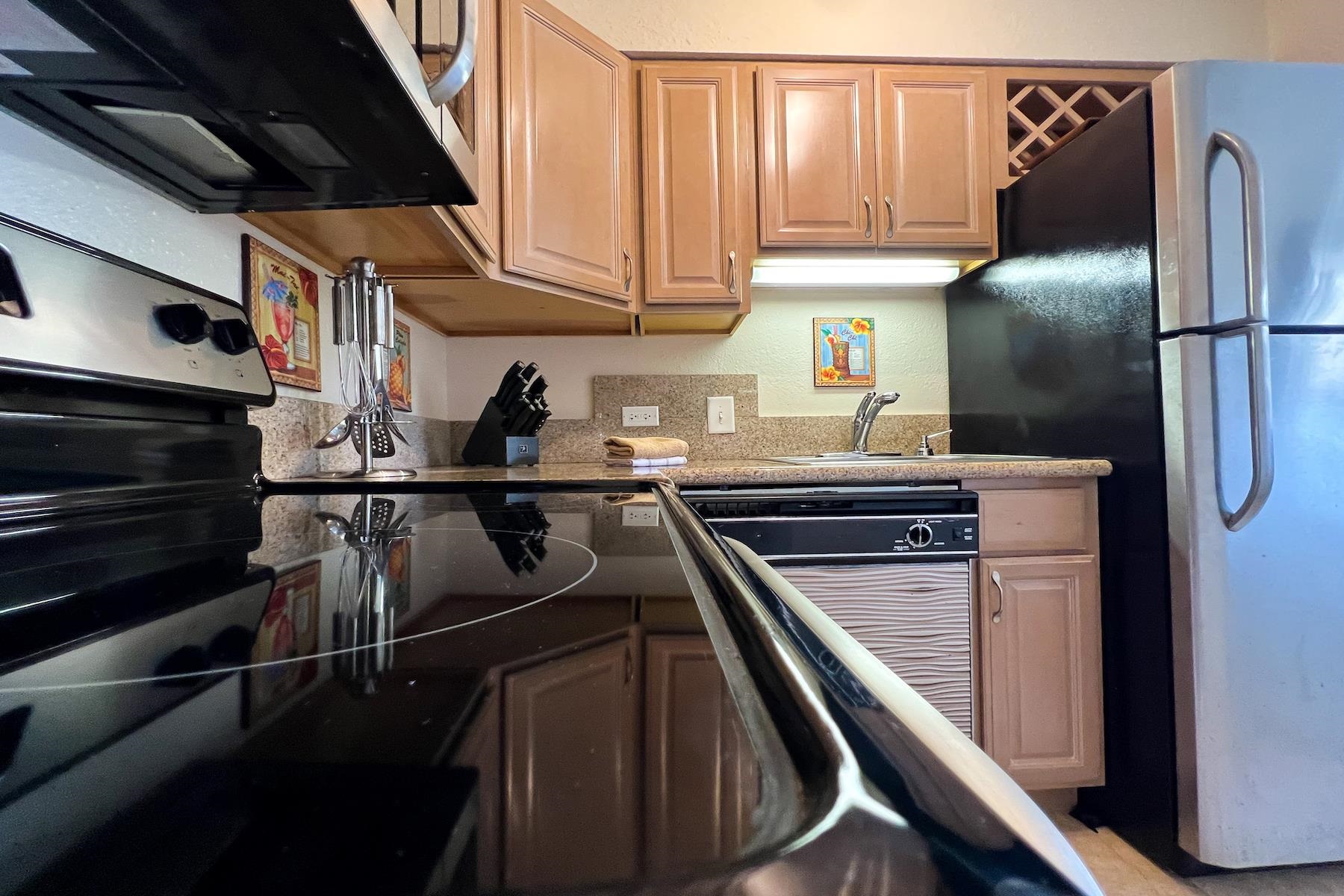 3601 Lower Honoapiilani Road, Unit 414 Lahaina, HI 96761 - Photo 10 of 28 a kitchen with a refrigerator stove and cabinets