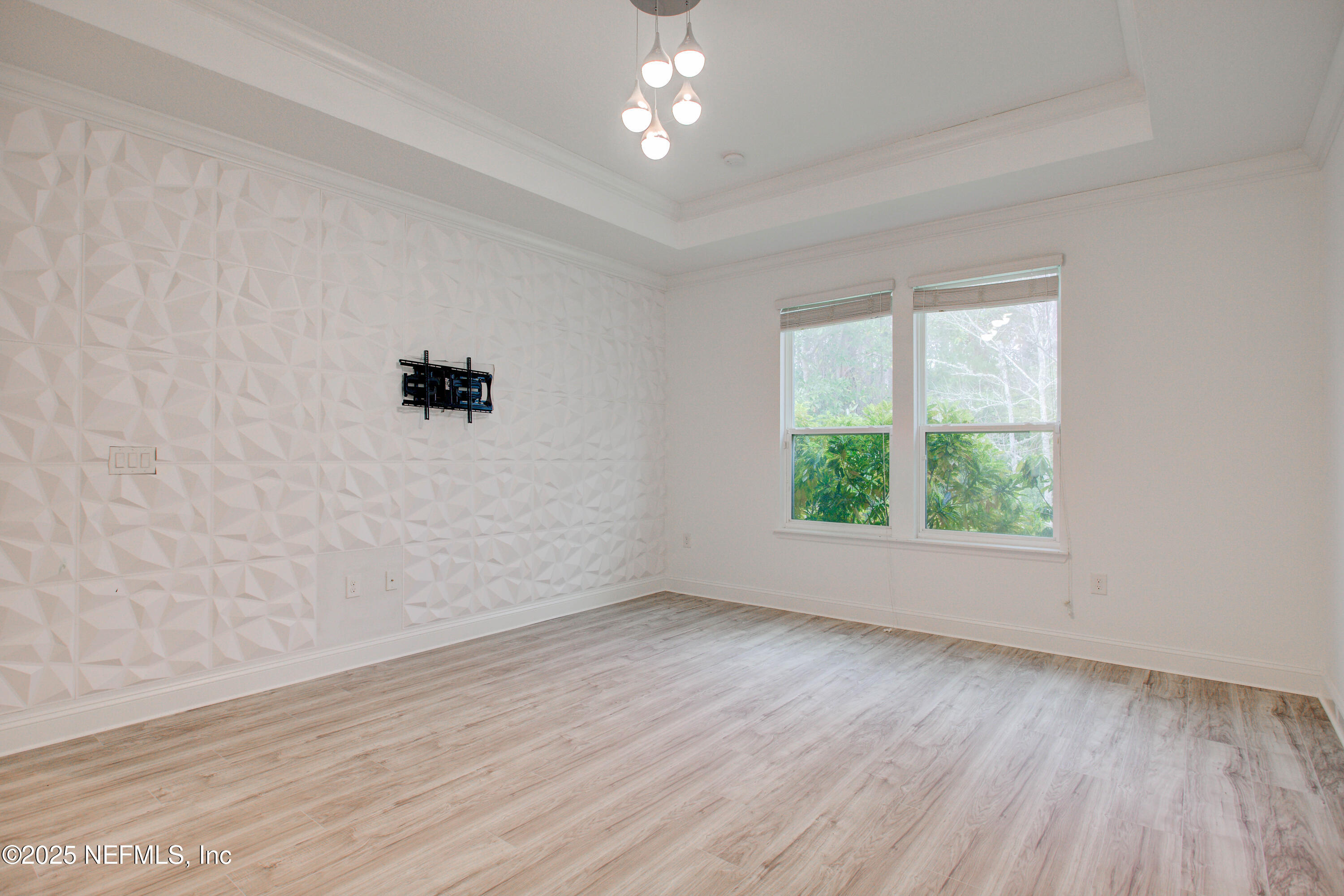 174 Antilles Road St. Augustine, FL 32092 - Photo 49 of 88 an empty room with wooden floor chandelier fan and windows