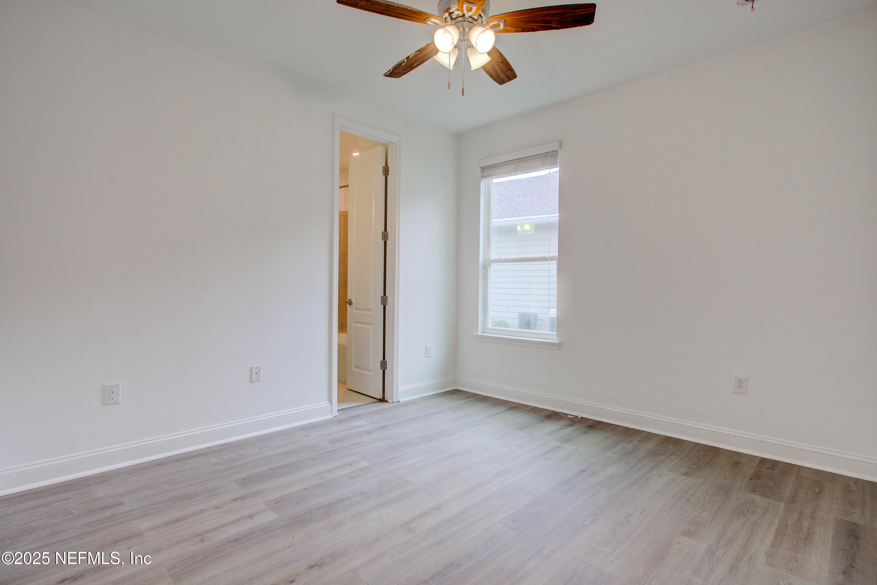 174 Antilles Road St. Augustine, FL 32092 - Photo 62 of 88 an empty room with wooden floor chandelier fan and windows
