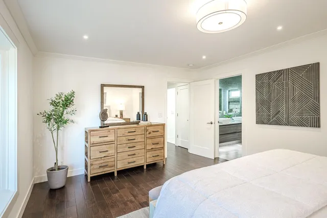 a bedroom with a bed and a potted plant