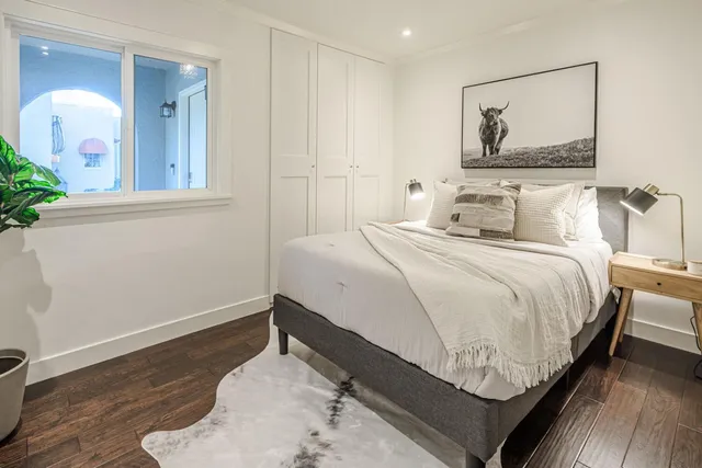 a bedroom with a bed and a painting on the wall