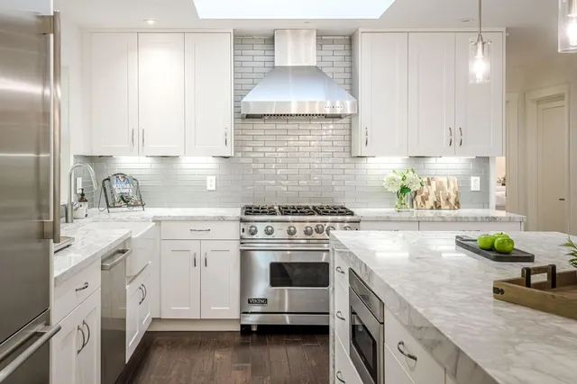 a kitchen with granite countertop a sink stove and cabinets