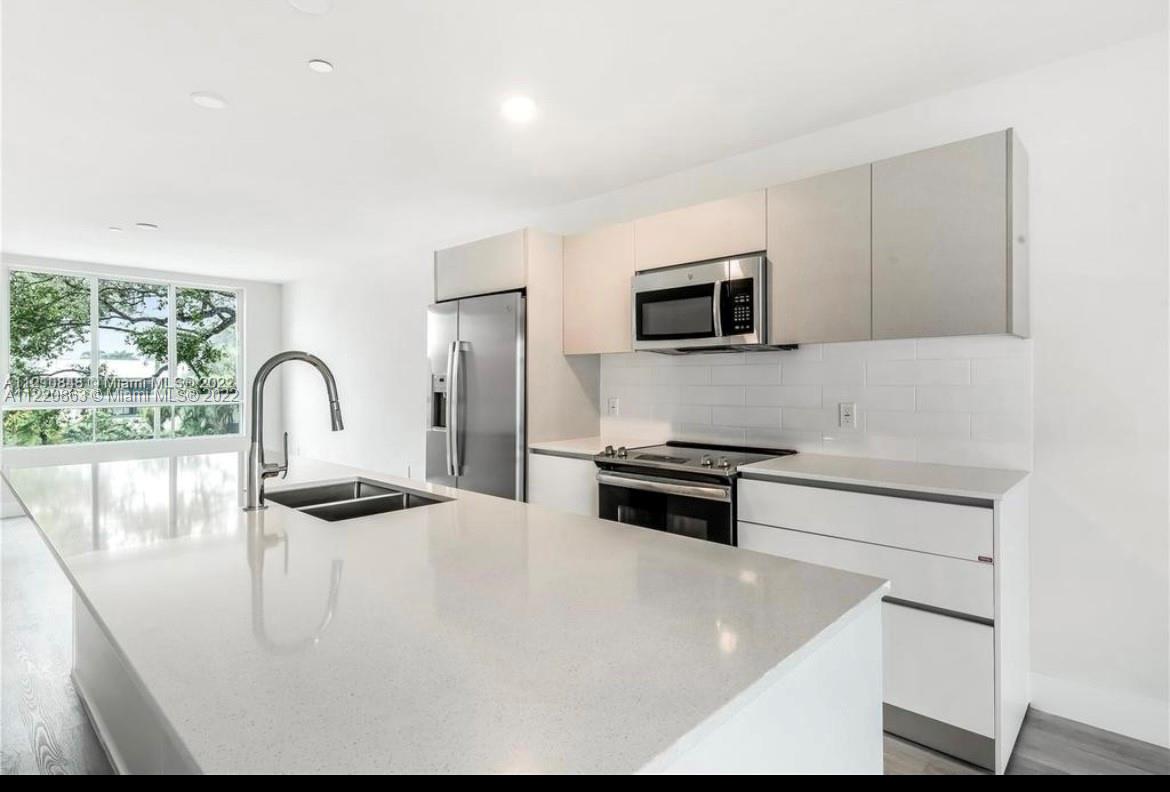 Ojus Miami, FL 33180 - Photo 8 of 10 a kitchen with stainless steel appliances and white cabinets